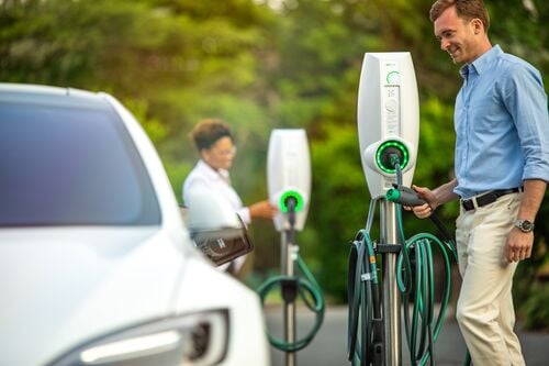 A gentleman using an EVBox business line EV charging station on a seemingly sunny day.