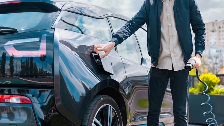 Modern person about to charge an electric car