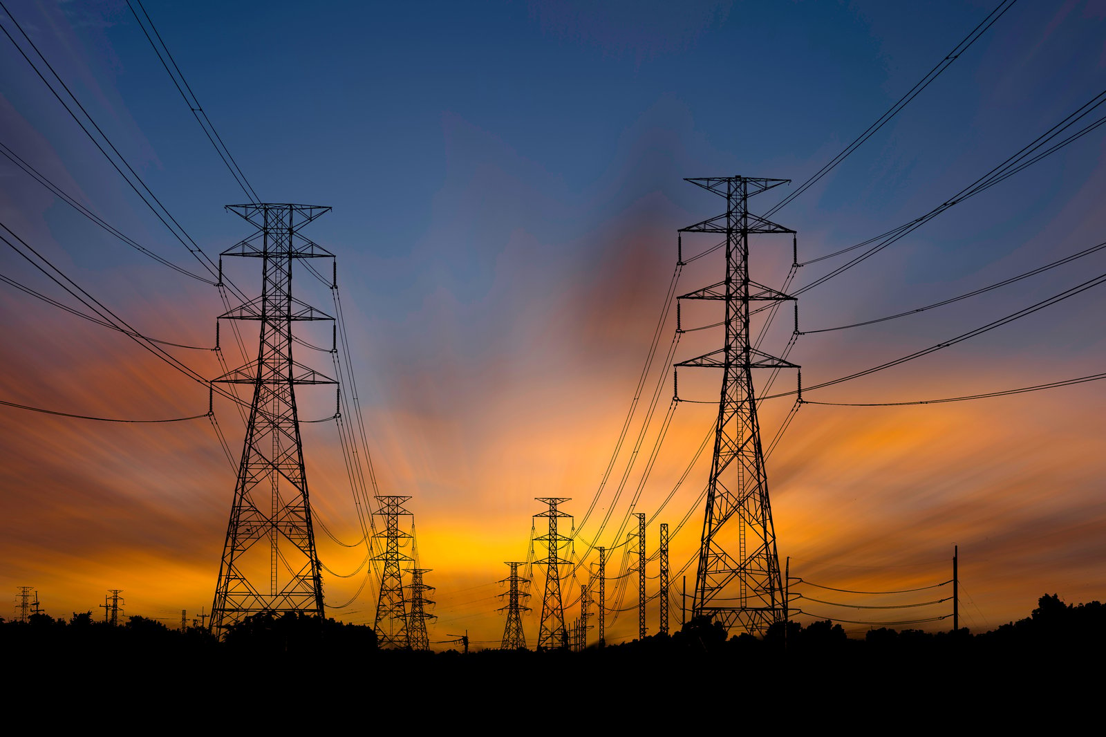 A series of power grids during sunset.