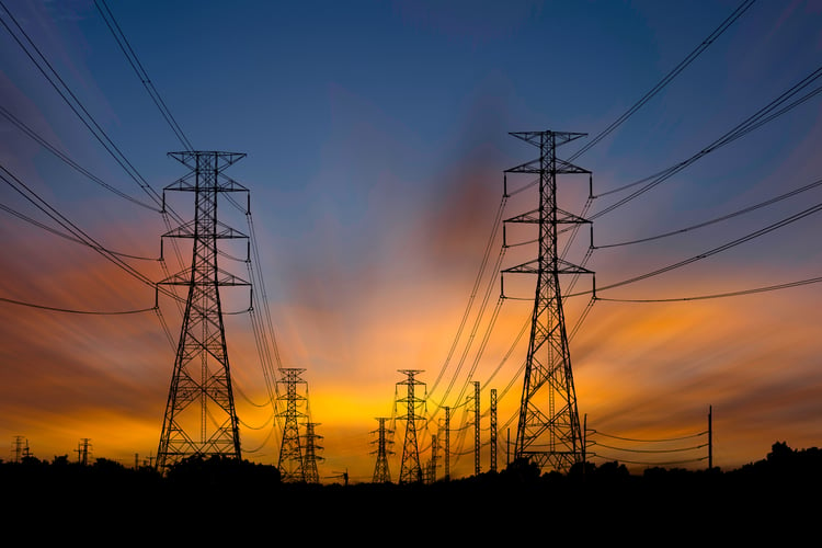 A series of power grids during sunset.