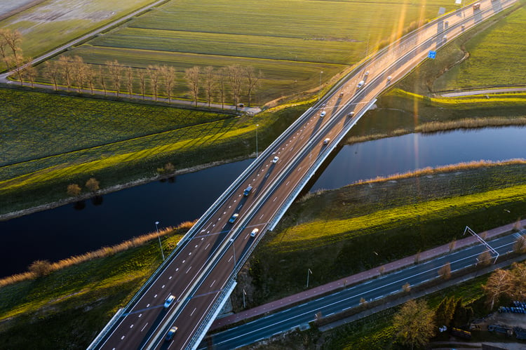 An aerial photograph of an highway viaduct in a countryside landscape at sunset.