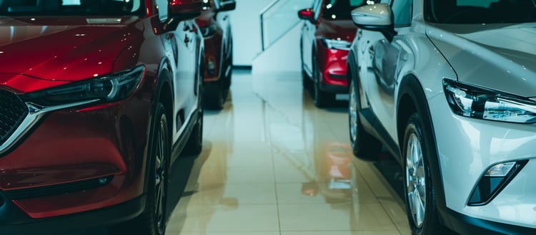 A closeup of several new electric SUVs parked in a car dealership.